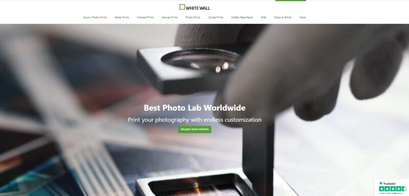 Close-up of photo prints being reviewed with a magnifier at WhiteWall, highlighting high-end printing precision
